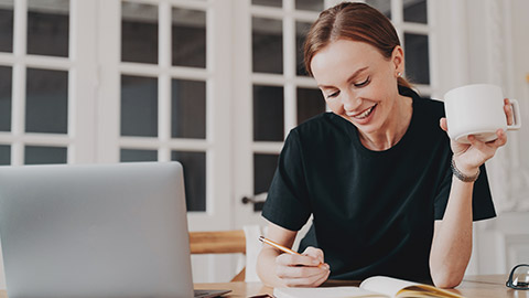 A childcare worker writing notes on paper in a relaxed environment