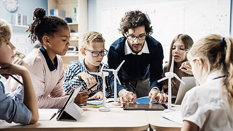 A teacher interacting with a group of children in a classroom