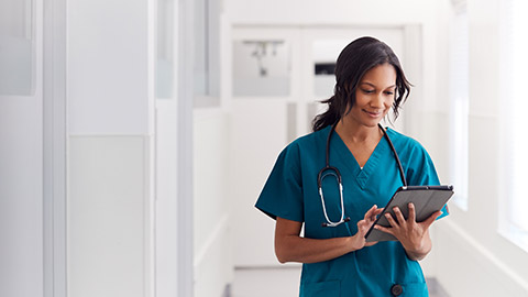 A nurse reading information on a tablet device