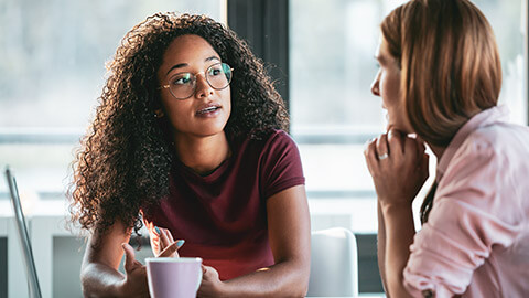 2 aged care workers discussing a matter in an office setting