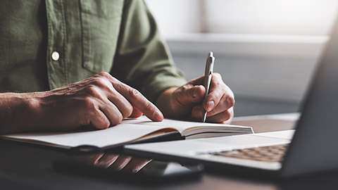 A person writing notes in a book