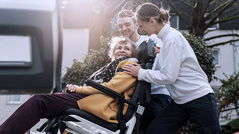 Two assistants helping a disabled woman