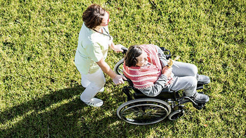 Elderly woman assisting by a nurse outdoor