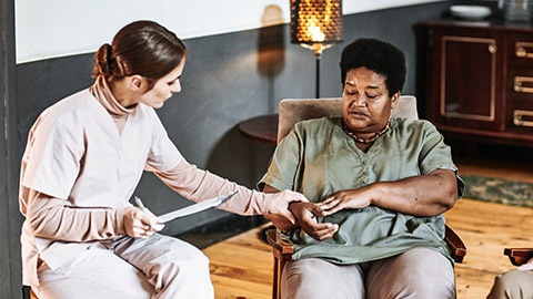 Dark skinned woman checks the pulse by a nurse