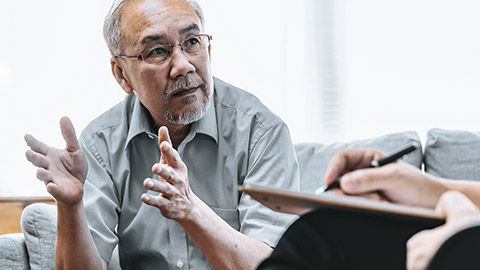 Senior man answering questions from health practitioner