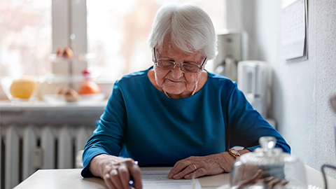 Elderly woman filling out financial statements