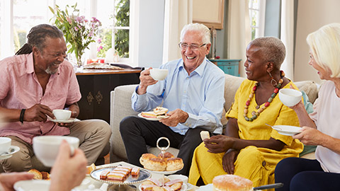 Group Of Senior Friends Enjoying Afternoon Tea At Home Together