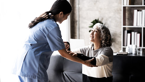 A nurse helping up an elderly