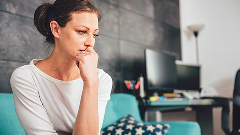 An upset woman sitting on a couch