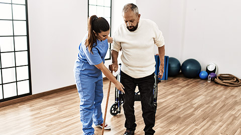 An elderly being helped up by a carer