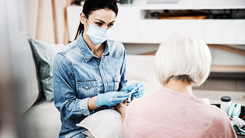 A person with minimal PPE taking care of an elderly