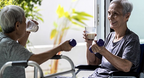 A pair of elderly people working out in a wheelchair