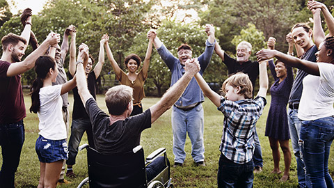 Group of people holding hand together in the park