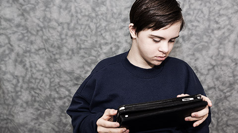 A special needs person holding a tablet