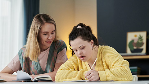 Young woman guiding a grl with disability