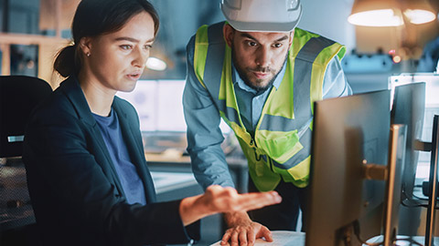 2 business colleagues discussing construction plans on a desktop computer