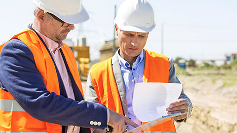 2 construction managers on site looking at paperwork