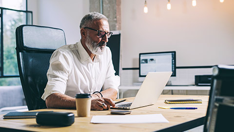 A professional seated at their desk reviewing the details of a construction contract