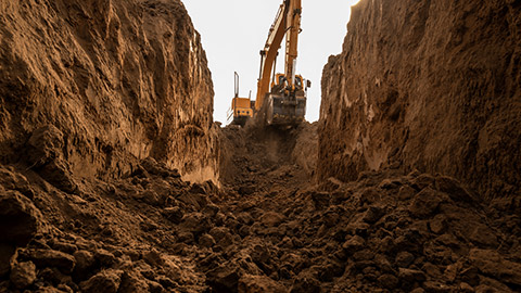 Excavator digging a trench for laying a pipeline