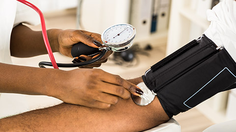 Doctor checking workers blood pressure