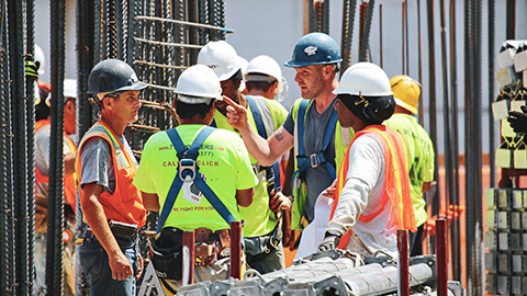 A foreman on a work site explaining procedures to construction workers