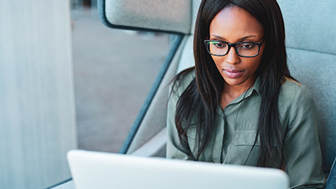 A business professional looking intently at a computer screen while gathering project-related information