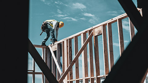 A carpenter working on the framework of a new house