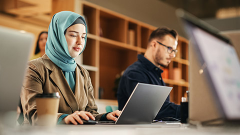 An accountant checking data on a laptop in a modern office space