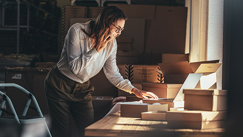 A small business owner checking stock while talking on a mobile phone