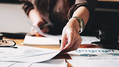 A close view of an accountant moving paperwork on a table