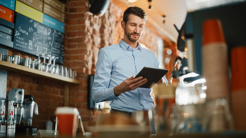 A busienss owner checking financial information in his cafe