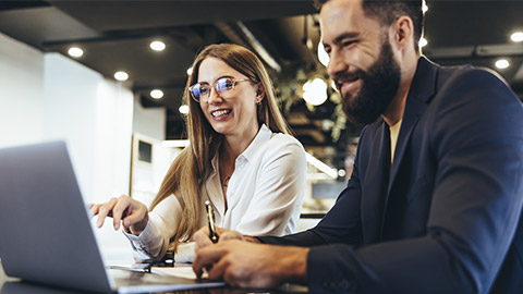 Cheerful businesspeople using a laptop in an office