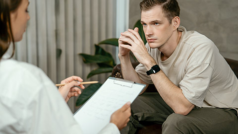 Stressed and depressed patient seeking help from psychiatrist with mental illness and depression in office during mental therapy session.