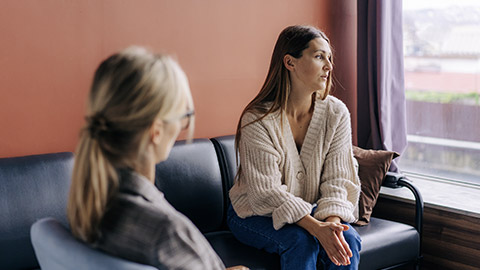 Sad frustrated woman talking in a session with a psychotherapist about her problems.