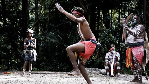 Indigenous Australian aboriginal People dancing to didgeridoo musical instrument sound rhythm in the tropical far north of Queensland, Australia.