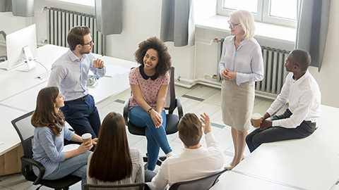 employees group discussing work plan with coach mentor at corporate office meeting