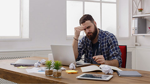 tired and stressed man working at his office