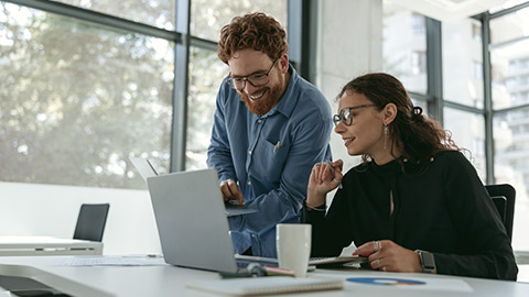 Two diverse business colleagues disscuss biz issue while use laptop in office background