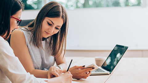 Two female colleagues in office working together.