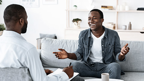 Cheerful man talking to psychologist