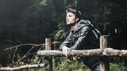 Man leaning on wooden fence