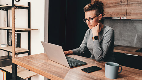 A small business owner checking financial records on a laptop