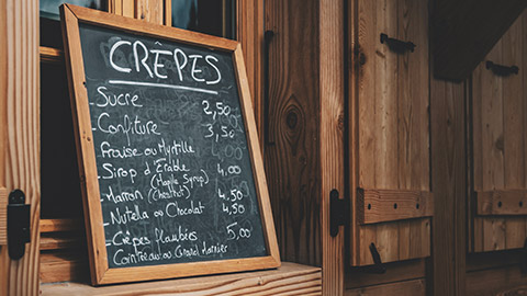 A menu signboard outside a cake