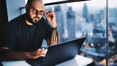 a person reading on a laptop on their balcony