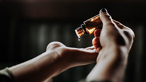 person holding amber glass bottle