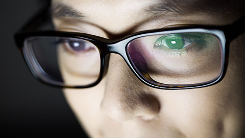 A person with glasses looking intently at a screen.