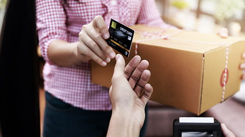 A person handing credit car for a delivery