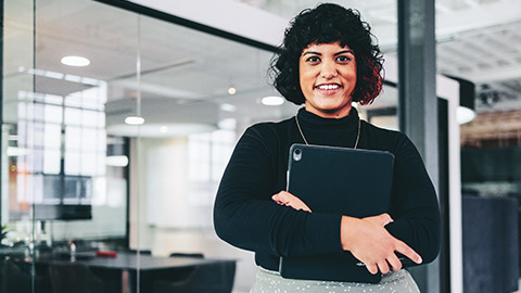 A young business professional standing in a modern office space