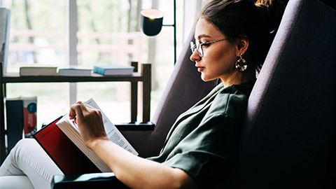 A person in a relaxed setting, catching up on some of the reading on their To-do list