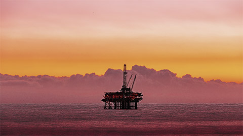 a lonely sea based oil rig at dusk